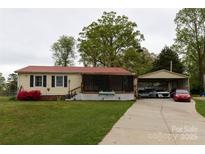 Charming single-story home with a well-manicured lawn and a detached carport at 115 Setter Ct, Statesville, NC 28625