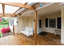 Inviting covered front porch with a swing and a well-maintained wooden deck at 115 Setter Ct, Statesville, NC 28625