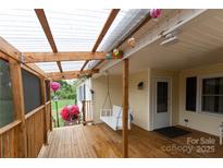 Inviting covered porch with swing, string lights, and wood flooring, perfect for relaxing outdoors at 115 Setter Ct, Statesville, NC 28625