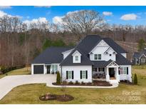 Stunning two-story home featuring a modern farmhouse design with a well-manicured lawn and black shutters at 129 Ryleigh Dan Pl, Mooresville, NC 28115