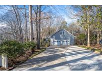 Detached two-car garage with long driveway nestled in a wooded lot at 140 Rustic Way Ln, Mooresville, NC 28117