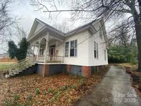 Side view of white home showing decorative porch with yard and driveway at 148 Center St, Chester, SC 29706
