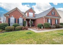 Charming brick home featuring a well-manicured lawn and classic architectural details at 2555 Holly Oak Ln, Gastonia, NC 28056