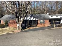Charming brick home with a screened-in porch and attached carport, nestled among mature trees at 314 Little St, Lincolnton, NC 28092