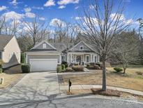 Charming single-story home featuring a two-car garage, well-manicured lawn and mature trees at 51273 Daffodil Ct, Indian Land, SC 29707