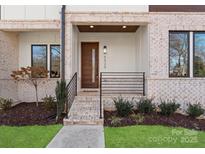 Welcoming front entrance with brick steps and modern door, complemented by a neatly landscaped yard at 5520 Chedworth Dr, Charlotte, NC 28210
