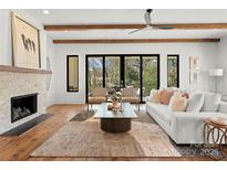 Bright and airy living room with a fireplace and access to the outdoor patio at 5520 Chedworth Dr, Charlotte, NC 28210
