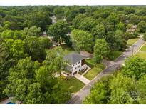Stunning aerial view of a two-story home nestled among lush greenery in a serene neighborhood at 5610 Farmbrook Dr, Charlotte, NC 28210