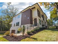 Stunning modern home with a striking facade, landscaped yard and a prominent staircase entrance at 5610 Farmbrook Dr, Charlotte, NC 28210