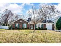 Charming brick ranch-style home featuring a well-maintained yard and attached garage at 605 Ridgeway Dr, Belmont, NC 28012