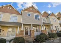 Charming townhome with stone accents, covered porch, and well-maintained landscaping at 11013 Dundarrach Ln, Charlotte, NC 28277