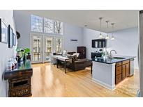 Bright open-concept living area with hardwood floors, high ceilings, and a modern island kitchen at 121 Irving Ave # F, Mooresville, NC 28117