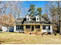 Charming home with a covered front porch and well-manicured yard, nestled among mature trees at 177 Highland Woods Ct, Denver, NC 28037