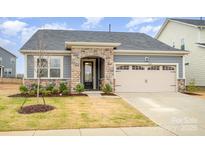Charming home with stone accents, attached two-car garage, and well-maintained front yard at 2405 Lorelei Ter, Monroe, NC 28112