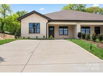 Inviting single-story home showcasing a spacious driveway, manicured landscaping, and a charming brick facade at 2425 Ellen Ave, Charlotte, NC 28208