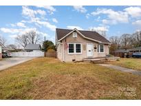 Charming single-story home featuring a cozy front porch and well-maintained lawn on a sunny day at 306 W 2Nd St, Cherryville, NC 28021