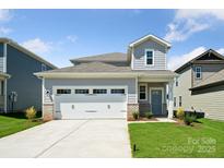 Charming two-story home featuring an attached two-car garage, well-manicured lawn, and appealing architectural details at 310 Bezelle Ave, York, SC 29745
