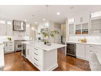 Spacious kitchen with stainless steel appliances, wine cooler, hardwood floors and white cabinets at 409 Running Horse Ln, Waxhaw, NC 28173