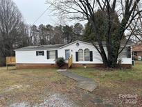 Charming home featuring a welcoming front entrance, classic black shutters, and a lovely yard at 459 Towell St, Mooresville, NC 28115