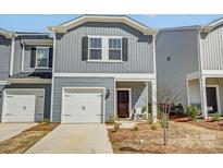 Charming gray townhome with a single-car garage and inviting front entrance with landscaping at 502 Tayberry Ln, Fort Mill, SC 29715