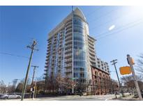 Modern high-rise condo building with curved glass and white balconies on a sunny day at 505 E 6Th St # 1006, Charlotte, NC 28202