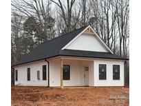Charming white home with black roof, siding, and dark framed windows, surrounded by bare trees at 635 Academy St, Cleveland, NC 27013