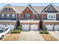 Charming brick townhome featuring a two-car garage, well-maintained landscaping, and a welcoming entrance at 107 Dellbrook St # B, Mooresville, NC 28117