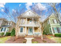 Charming two-story home boasts a welcoming front porch and manicured landscaping at 13527 Davidson Place Dr, Davidson, NC 28036