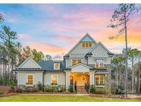 Beautiful two-story home featuring stone accents, manicured lawn, and a welcoming front porch at sunset at 3288 Sherman Dr, Lancaster, SC 29720