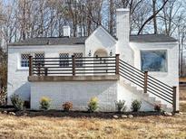 Charming white brick home featuring a cozy front porch, decorative windows and manicured landscaping at 32884 Old Salisbury Rd, Albemarle, NC 28001
