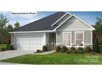 Charming single-story home featuring a two-car garage, stone accents, and manicured landscaping at 338 Knotty Wood Dr # 69, Monroe, NC 28110