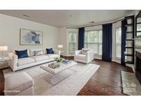 Bright living room featuring a plush white sofa, modern decor, and hardwood floors at 521 N Graham St # 2B, Charlotte, NC 28202