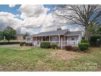 Charming single-story home featuring a welcoming front porch and beautifully landscaped front yard at 816 South Point Rd, Belmont, NC 28012