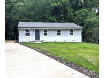 Charming single-story home with gray siding, a well-manicured lawn, and a newly paved concrete driveway at 1522 Wickham Ln, Charlotte, NC 28208