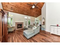 Bright living room with a wood-paneled vaulted ceiling, fireplace, and hardwood floors at 10213 Conistan Pl, Cornelius, NC 28031