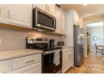Well-equipped kitchen showcasing stainless steel appliances, white cabinetry, and modern countertops at 3156 Pinehills Way, Mount Holly, NC 28120