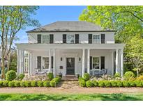 Charming two-story white brick home with black shutters, elegant columns, and professionally landscaped front yard at 332 Hempstead Pl, Charlotte, NC 28207