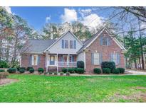 Charming brick home featuring a manicured lawn and a welcoming front porch, adorned with blue shutters at 340 Tradewinds Ln, York, SC 29745