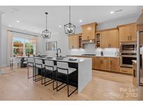 Modern kitchen featuring an island with a quartz countertop, pendant lights, and stainless steel appliances at 8004 Brookbank Dr, Charlotte, NC 28269