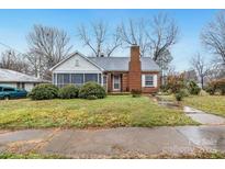 Charming brick home features a cozy screened-in porch and mature landscaping at 801 E Liberty St, Salisbury, NC 28144