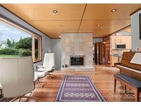 Bright living room with modern fireplace, hardwood floors, ample natural light and refined furnishings at 105 Hillside Dr, Davidson, NC 28036
