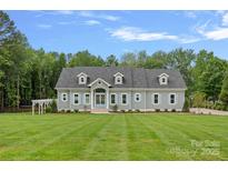 Charming single story home featuring gray siding, dormer windows, a manicured lawn, and a beautiful blue sky at 111 Kent Ct, Mooresville, NC 28117