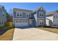 Charming two-story home with stone accents, a two-car garage and a spacious concrete driveway at 133 Batten Ridge Dr, Statesville, NC 28677