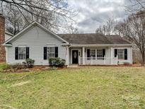 Charming home featuring a manicured front lawn and classic curb appeal with black shutters on the windows at 14621 Sapphire Ln, Pineville, NC 28134