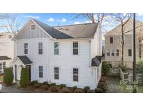 Bright exterior of a two story home with white siding, black roof, and well-maintained landscaping at 1503 Briar Creek Rd # Apt B, Charlotte, NC 28205
