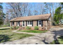 Charming brick home with manicured lawn, black shutters, and inviting front entrance at 2537 Wood Star Ct, Matthews, NC 28105