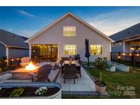 Relaxing backyard features a fire pit and outdoor dining area, perfect for entertaining in the evenings at 4023 Gozzi Dr, Iron Station, NC 28080