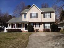 Charming two-story home with neutral siding, black shutters, covered porch, and well-manicured landscaping at 6622 Cedar Cliff Dr, Charlotte, NC 28216