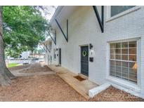 Charming townhouse featuring a white brick exterior and black trim accents at 921 Ambassador St # 1, Charlotte, NC 28208