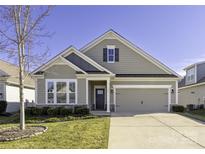 Charming one-story home with stone accents, manicured lawn, and attached two car garage at 106 Chase Water Dr, Mooresville, NC 28117